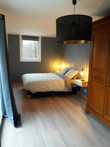 VerlinghemPause Messines Chez Anne-Marie的一间卧室设有一张大床和一个窗户。