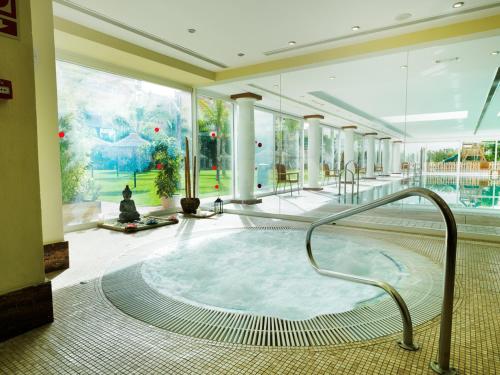 福恩吉罗拉莫纳克福恩吉罗拉公园酒店的大型客房设有一个热水浴缸和大窗户