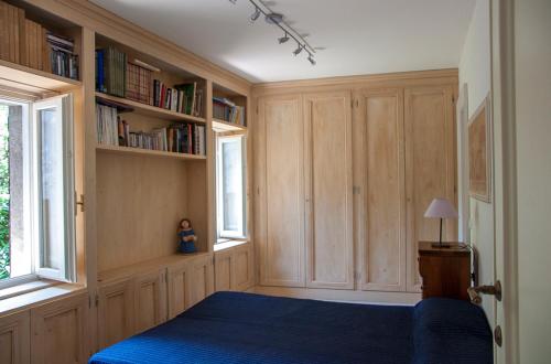 加尔多内-里维耶拉Charming rustic house的一间卧室配有蓝色的床和书架