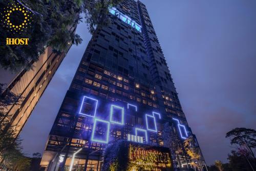 吉隆坡Expressionz Suites By iHost Global的一座高大的建筑,上面有蓝色的灯光