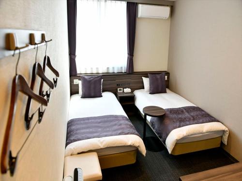 Neyagawa大阪寝屋川新指挥官酒店的小房间设有两张床和窗户