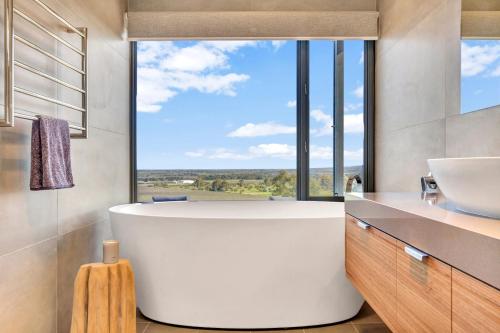 麦克拉伦谷Shadow Creek McLaren Vale的一间带大窗户的浴室内的白色大浴缸
