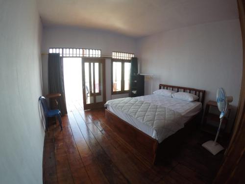 Kaloa奥拉日出景观度假酒店的一间卧室配有一张床,铺有木地板