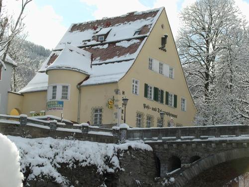 穆劳阿尔品穆劳酒店的一座建筑物,桥旁有雪盖屋顶