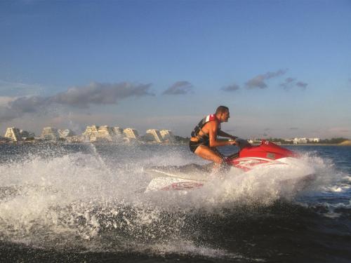 拉格朗德默特Vittoria Immobilier 7 - piscine - Terrasse - chèques vacances acceptés的水中骑摩托艇的人