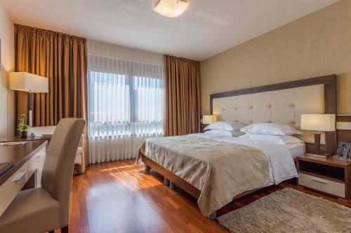 塞里特雷尼科德杰尼伽酒店的一间卧室设有一张大床和大窗户
