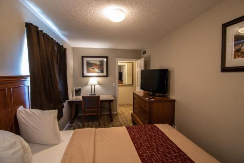 斯皮尔菲什Lookout Mountain Lodge的酒店客房配有一张床和一张书桌及一台电视