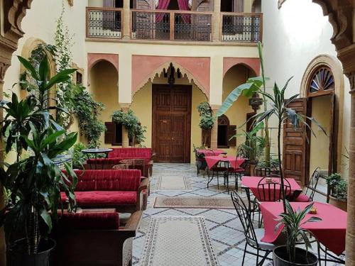 塞拉马里尼娜里亚德旅馆的餐厅设有红色的长沙发、桌子和植物