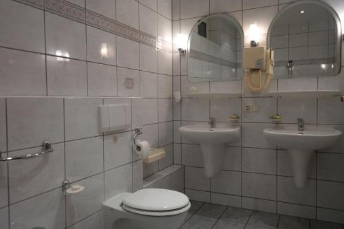 塔尔诺夫斯凯古雷VillaMirage的浴室设有2个水槽、卫生间和镜子。