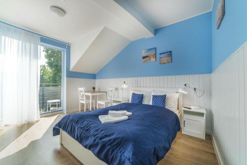 加茨比亚格拉Papaj Resort的蓝色卧室,配有床和桌子