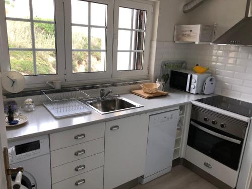 福斯·杜·阿勒奥Salty House - Casa Salgada的厨房配有水槽和微波炉