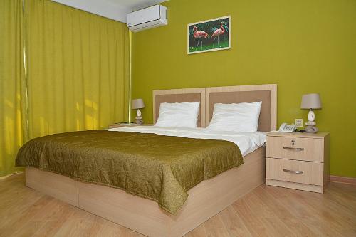 巴库Flamingo Hotel Baku的一间卧室设有一张带绿色墙壁的大床