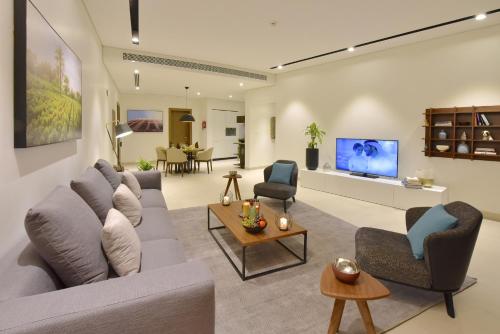 麦纳麦Swiss-Belresidences Juffair的客厅配有沙发、椅子和电视