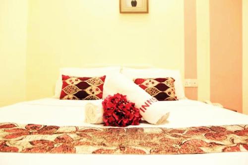 八打灵再也门特里阳光大道阳光旅馆的一张带枕头的白色床和红色的鲜花
