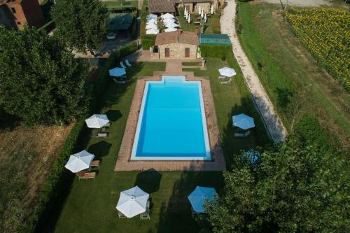 阿雷佐里肯帕内酒店的享有带遮阳伞的庭院游泳池的顶部景致