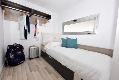 阿马多雷斯Beyond Amadores C&H Suite Nº4的一间卧室设有两张床、一个背包和一个窗户。