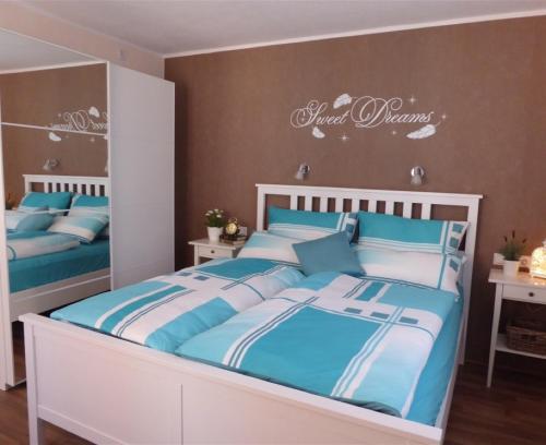 RambergFerienhaus Agnes的一间卧室配有两张带蓝白色床单的床