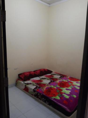 KalasanNusantara kost syariah bulanan harian的一间卧室配有一张带五颜六色棉被的床