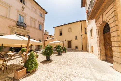 特雷维Palazzo Neri的老城区的一条小巷,里面设有桌子和遮阳伞