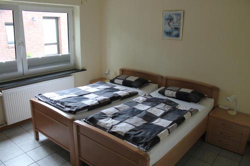 卡罗利嫩西尔Ferienwohnungen im Gästehaus Sieberns的带窗户的客房内设有两张单人床。