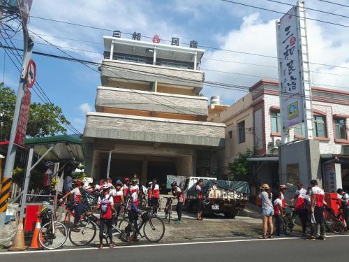 太麻里三和民宿的站在一座建筑前面的一群骑自行车者