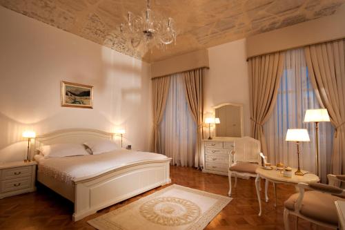卢布尔雅那Antiq Palace - Historic Hotels of Europe的一间卧室配有一张床、一把椅子和一张桌子