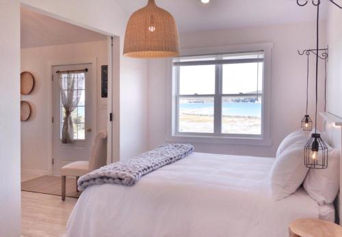 洛基港The Fish Sheds的一间卧室配有一张床,享有海滩美景