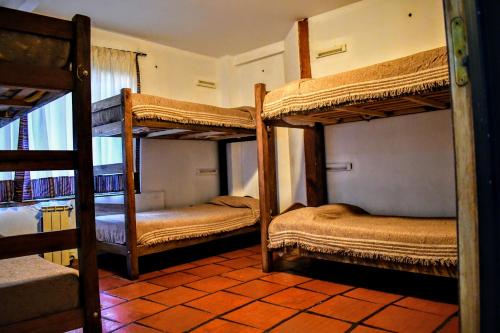 厄尔查尔坦Rancho Aparte Hostel的房屋内带三张双层床的房间