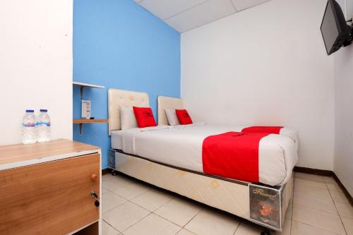 三宝垄RedDoorz Near Kota Lama Semarang的一间卧室配有一张带红色枕头的床