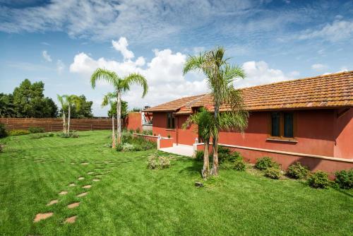 菲乌米奇诺Domus Porto Di Traiano Resort的一座棕榈树的红色房子