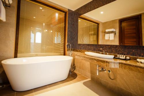 阿纳克利亚Anaklia Resort by Pratap's Signature的带浴缸、水槽和镜子的浴室