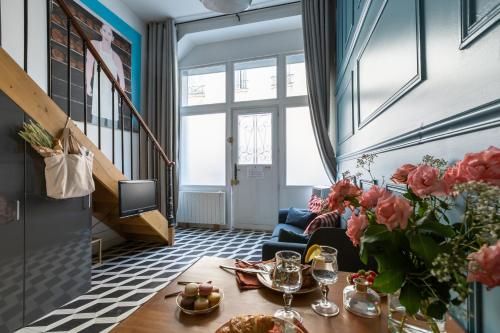 巴黎艺术阁楼公寓，毗邻玛瑞斯的客厅配有桌子和蓝色沙发