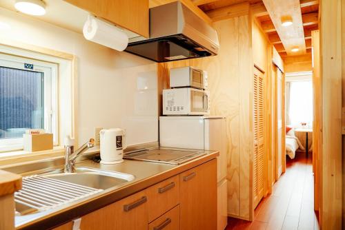 富良野Jstyle STAY Furano的厨房配有水槽和冰箱