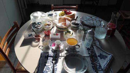 雷诺河畔卡萨莱基奥Casina Belvedere的一张带食物和饮料的白色桌子