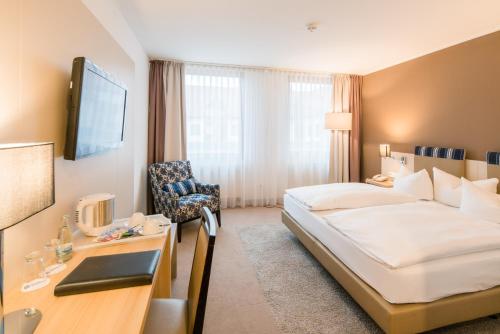 爱尔福特厄弗特-阿普费尔斯特贝斯特韦斯特酒店的配有一张床和一张书桌的酒店客房