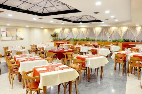 布兰卡港艾格洛斯酒店的一间设有白色桌椅的用餐室