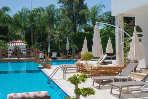 凯麦尔Sofia Residence的游泳池旁设有躺椅和遮阳伞的游泳池