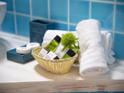 帕劳帕劳酒店的浴室柜台上的洗浴用品和毛巾篮