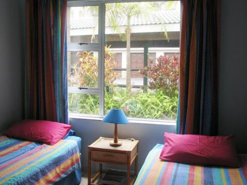 拉姆斯盖特Ramsgate Palms B的一间卧室设有两张床和大窗户