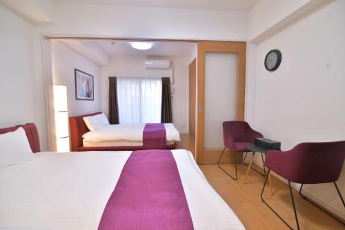 福冈European House Reisen的酒店客房带一张大床和两张椅子