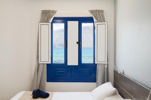 塞博河畔卡莱塔Apartamentos El Marinero - Caletilla的窗户房间里一扇蓝色的门