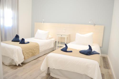 塞博河畔卡莱塔Apartamentos El Marinero - Iglesia的一间卧室配有两张床和蓝色毛巾。