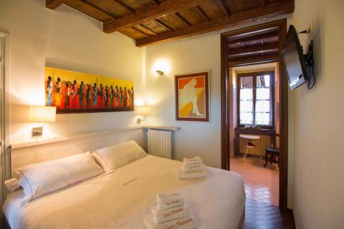 马斯诺维斯康蒂卡萨马瑞恰酒店的一间卧室配有一张床,上面有两条毛巾