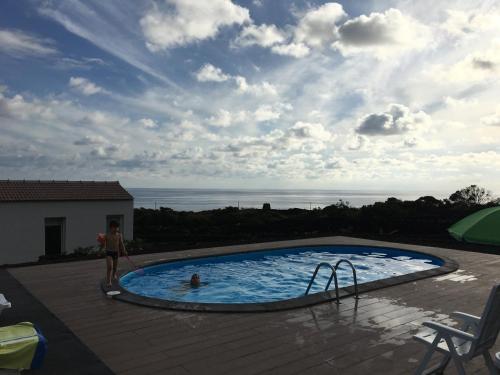 马达莱纳Insula Vinus Apartments的站在海洋游泳池旁的女人