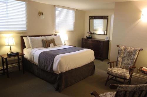 哈利法克斯哈里伯顿酒店的一间卧室配有一张床、一把椅子和镜子