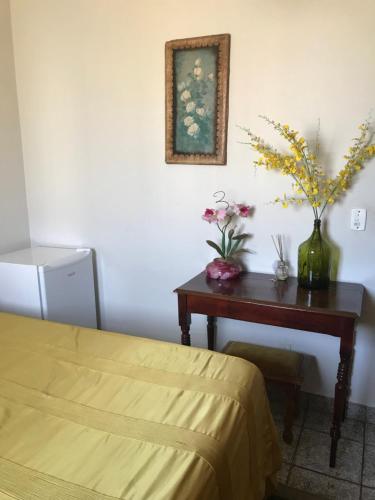 普雷图河畔圣若泽Espaco unico的一间卧室配有一张桌子、一张床和鲜花