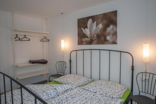鲁斯特Apartments "Happy Family"的一间卧室配有一张带两把椅子的床和一幅画