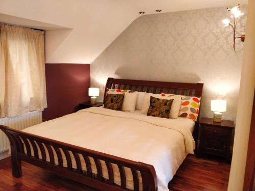 斯奇博瑞恩Luxury Skibbereen Town House的一间卧室配有一张大床和两盏灯