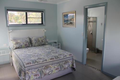 库克敦Gecko Guest House的一间卧室设有一张床、一个窗口和一间浴室