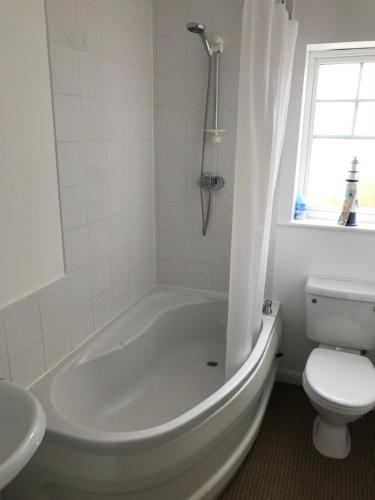 伊斯特布恩Eastbourne, Sovereign Harbour Holiday Home的白色的浴室设有浴缸和卫生间。